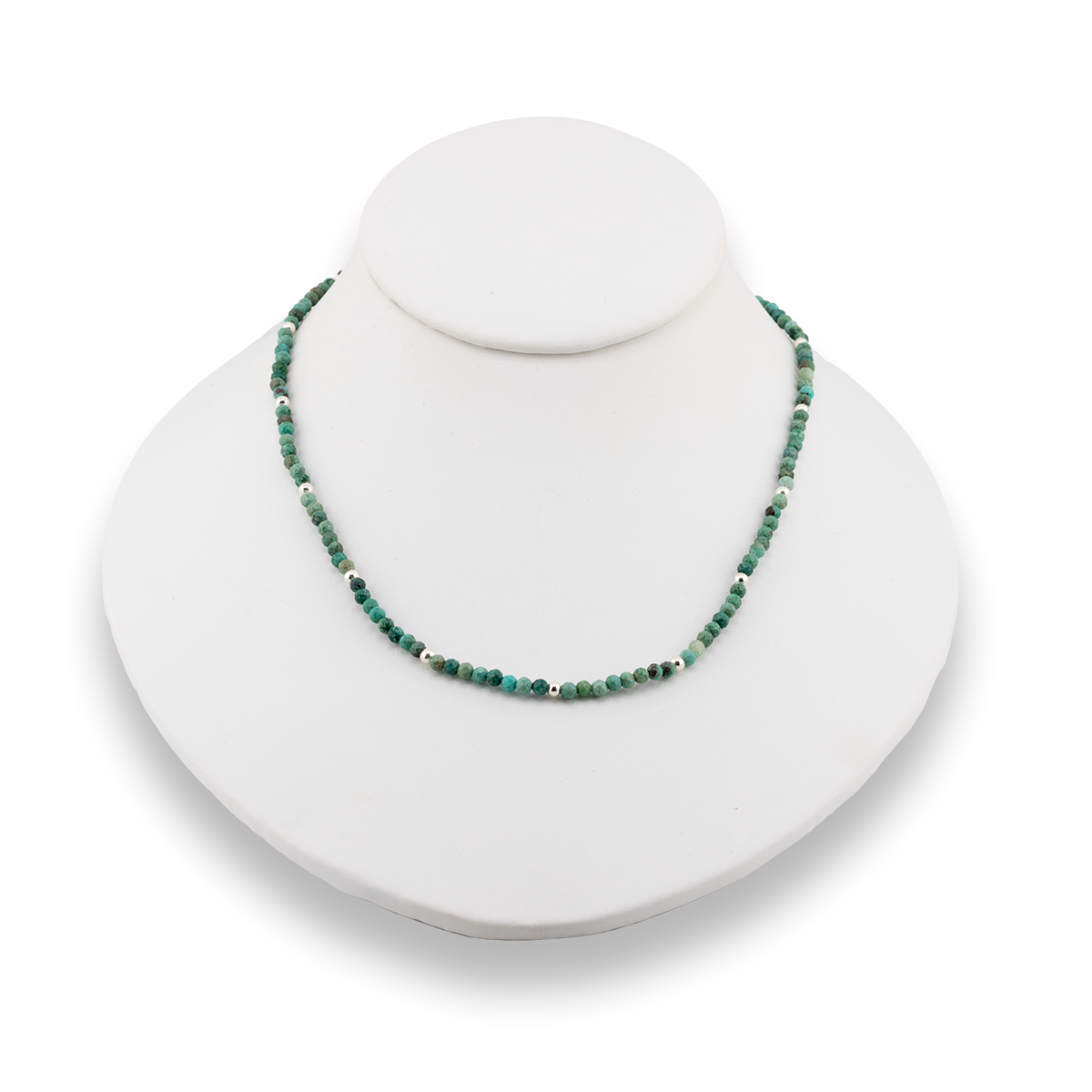 Green beaded necklace on a white jewelry display