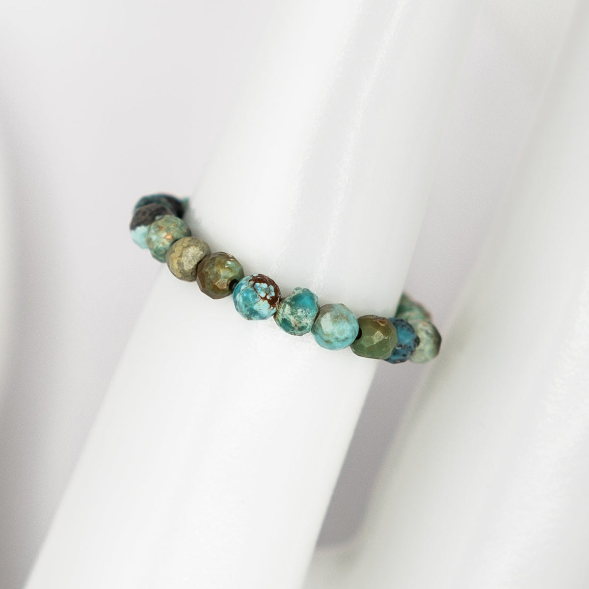 Bracelet with turquoise and brown beads on a white background
