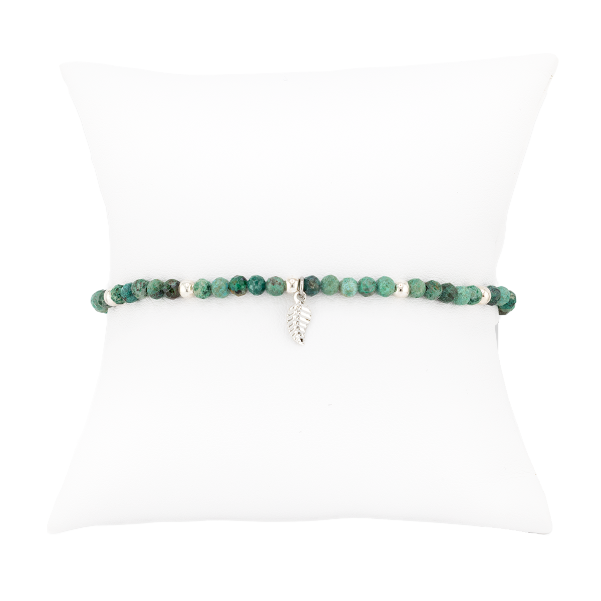 Green beaded bracelet with a silver charm on a white background