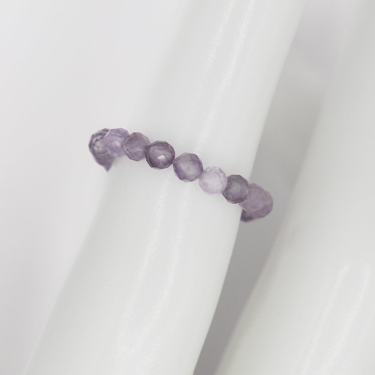 Purple beaded ring on a white background