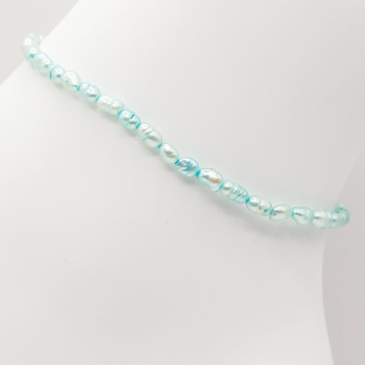 Beaded bracelet with blue and clear beads on a white background