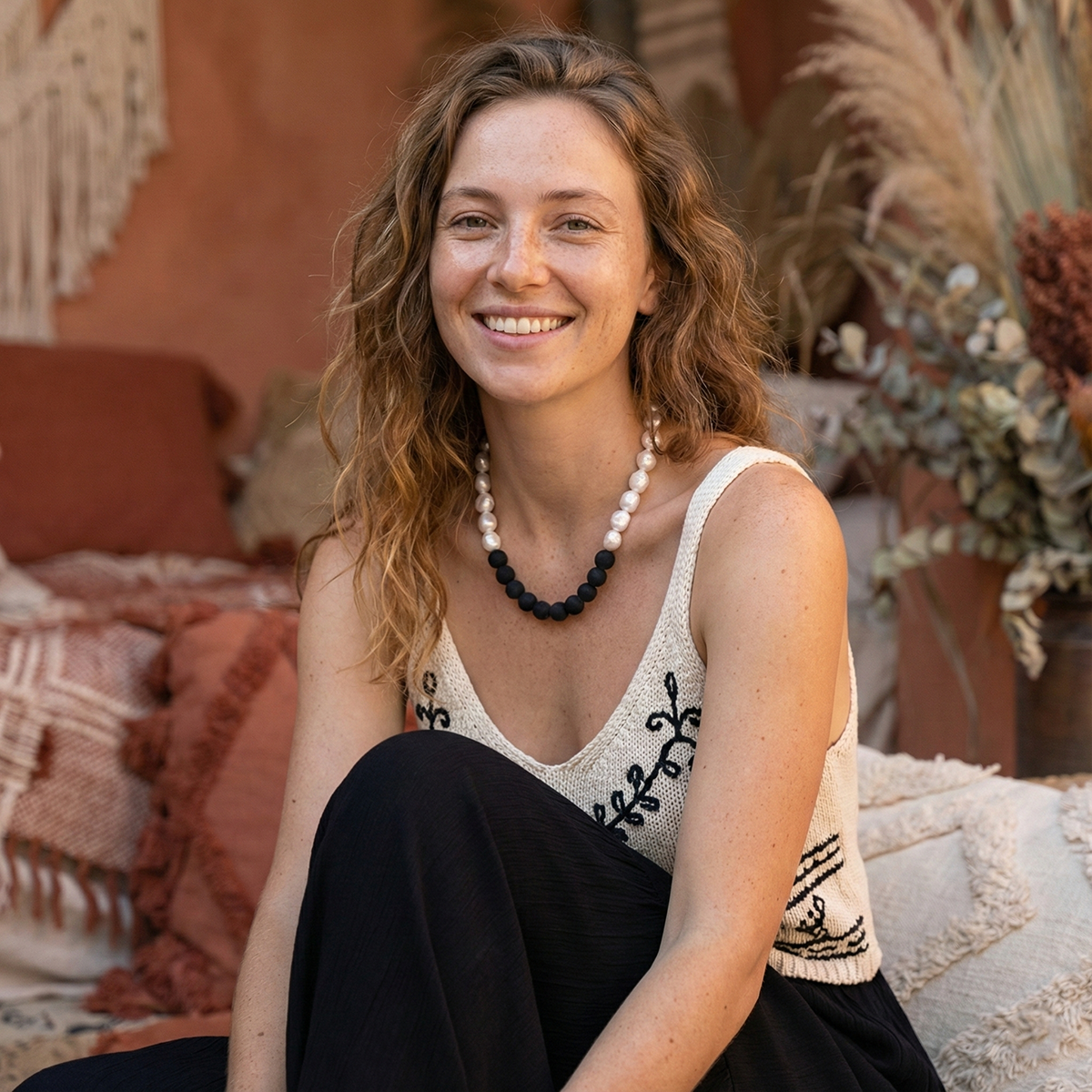 Woman sitting outdoors with a warm, earthy background