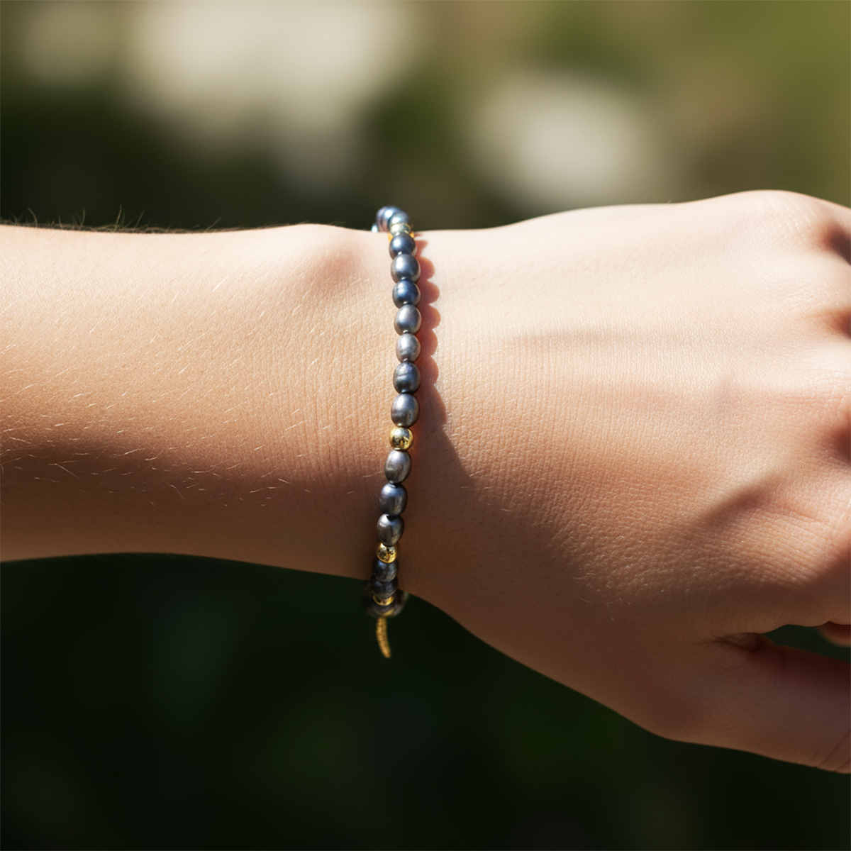 Close-up of a wrist wearing a beaded bracelet with a blurred natural background
