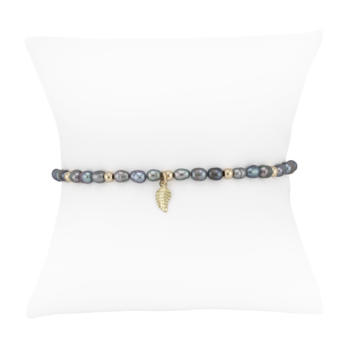 Pearl bracelet with a leaf charm on a white background