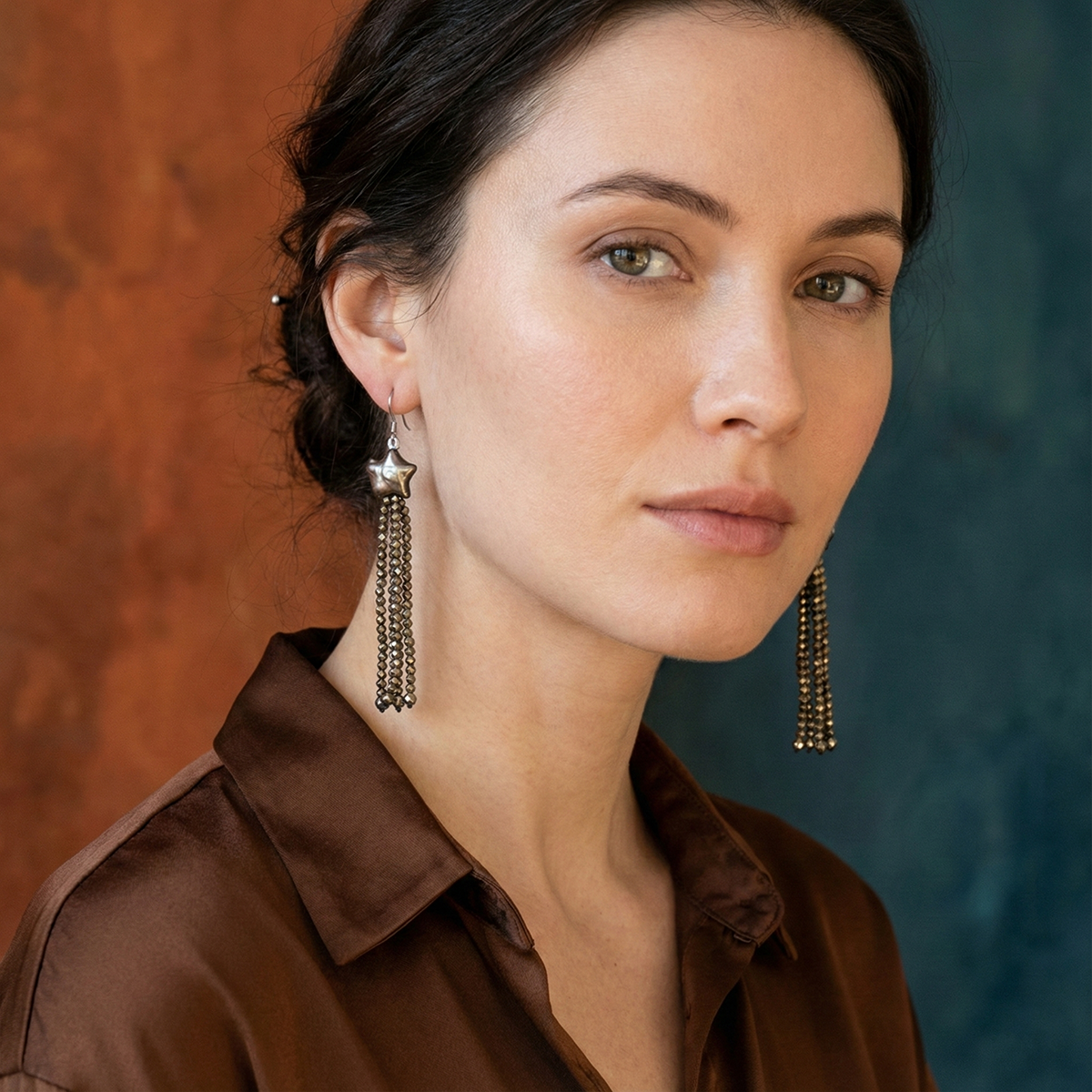 Woman wearing gold earrings with a blurred background