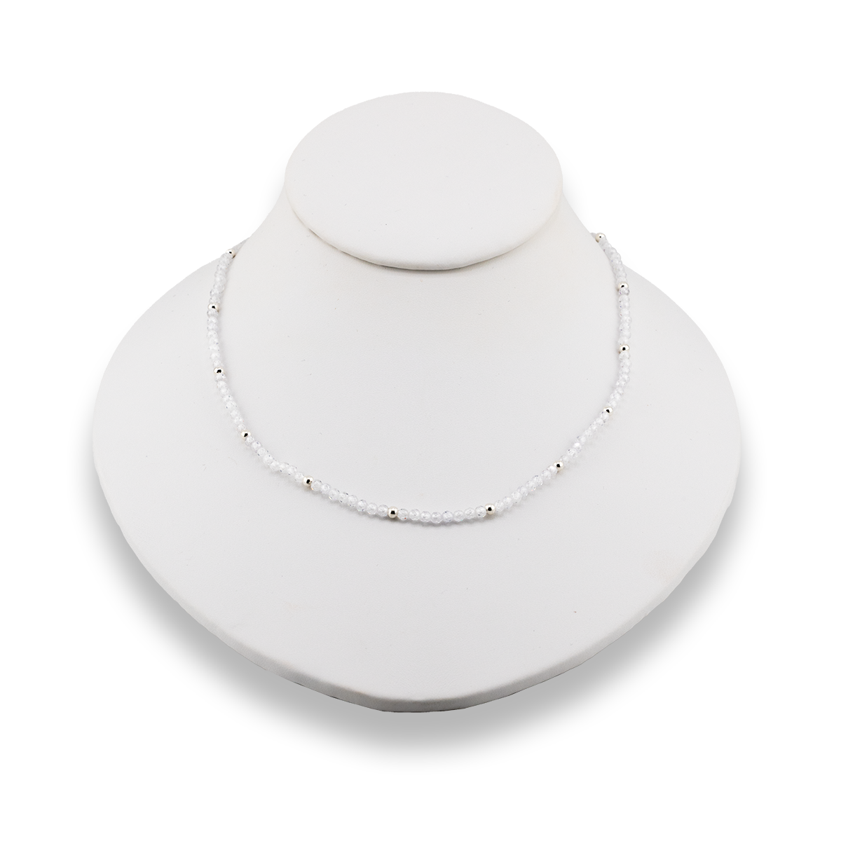Necklace on a white mannequin bust with a plain background