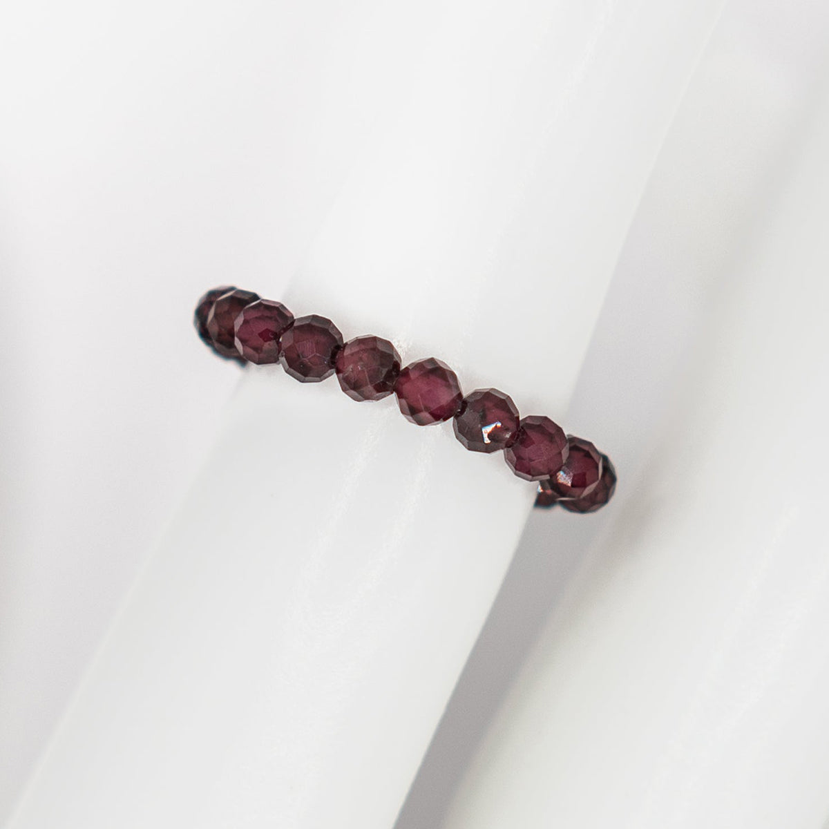 Beaded ring with red beads on a white background