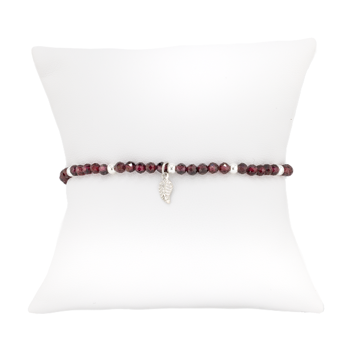 Bracelet with red beads on a white cushion