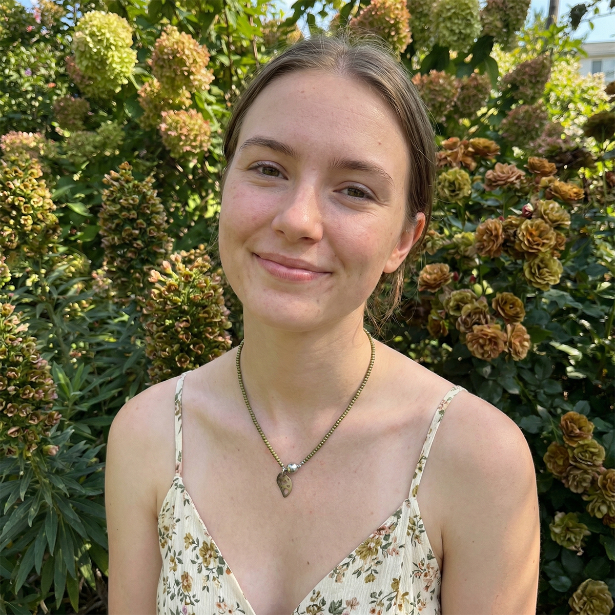 Woman standing in front of a garden with flowers