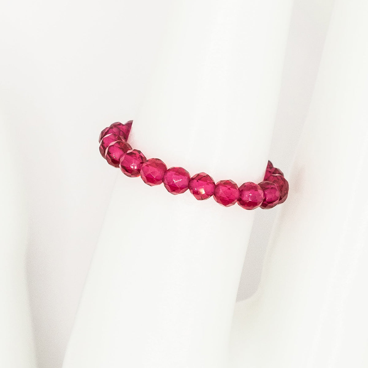 Pink beaded ring on a white background