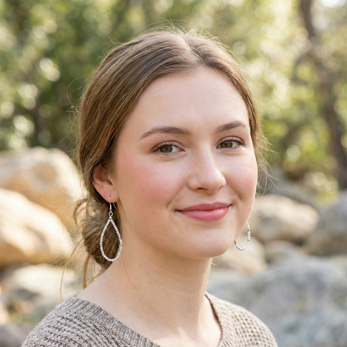 Woman with earrings standing outdoors with a natural background