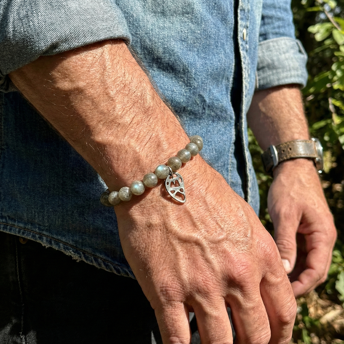Person wearing a bracelet with a heart charm outdoors