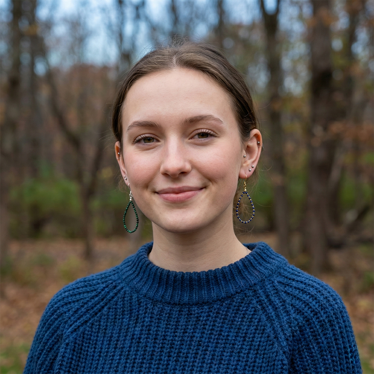 Woman wearing a blue sweater with a forest background