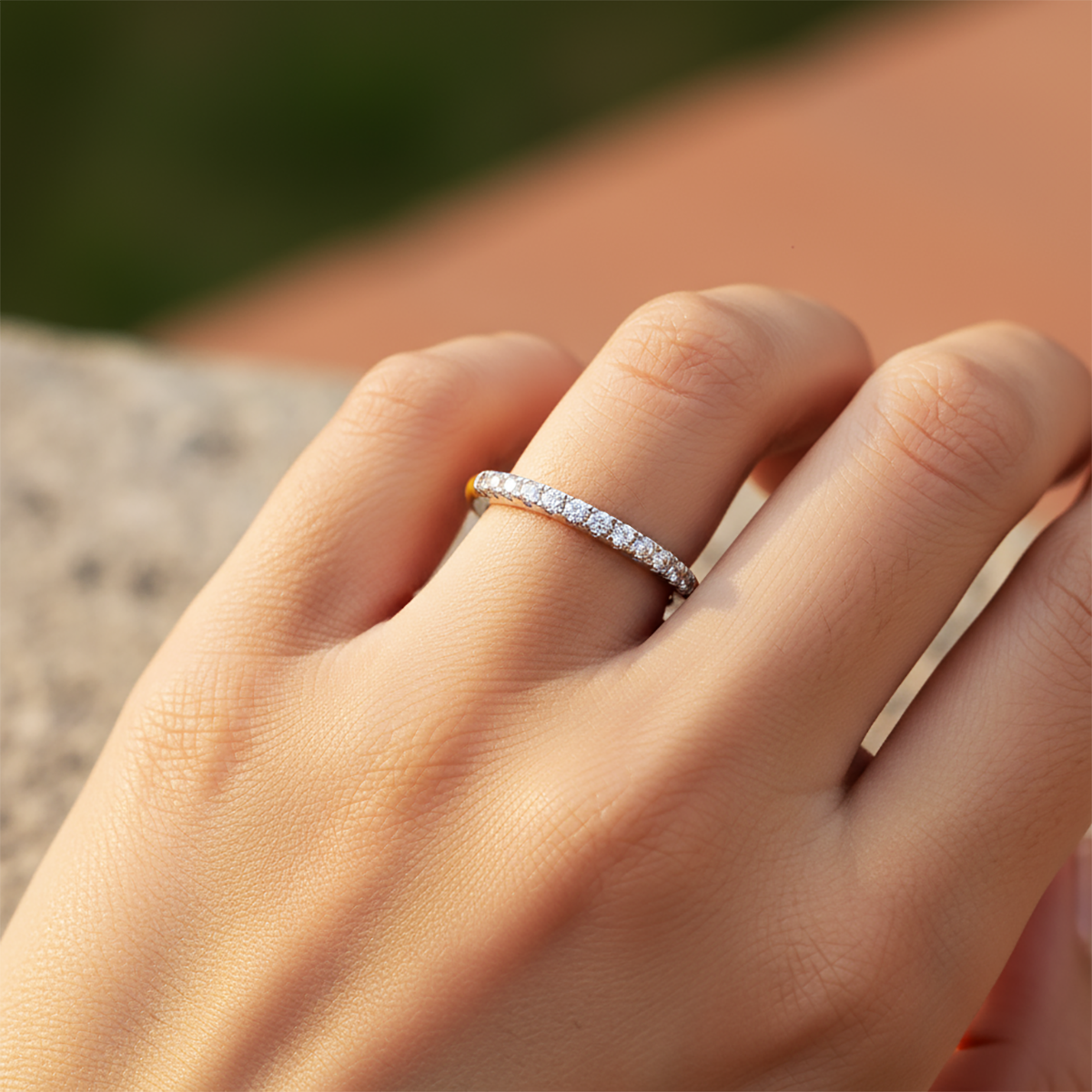 Close-up of a hand wearing a diamond ring with a blurred background