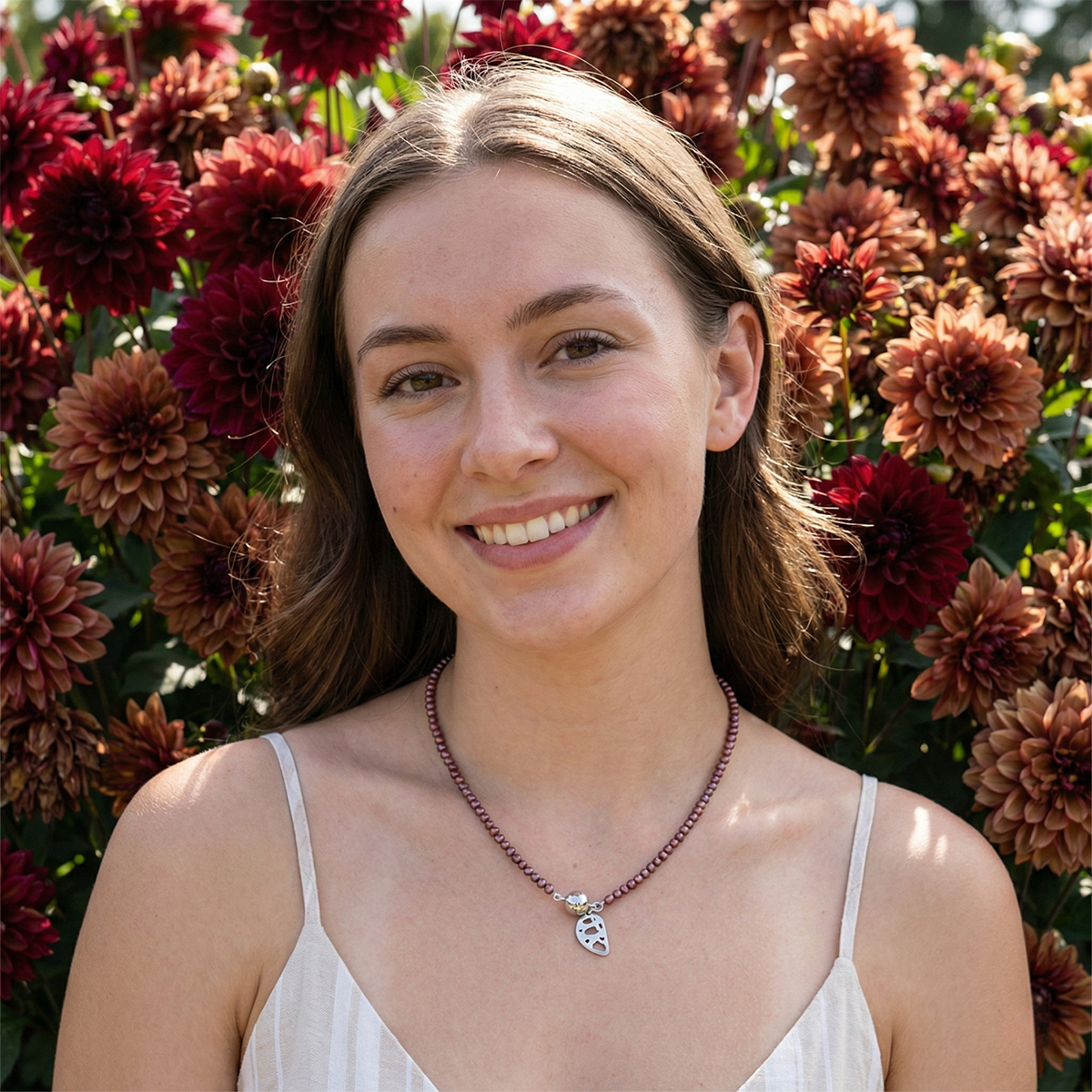 Woman standing in front of a field of red and brown flowers