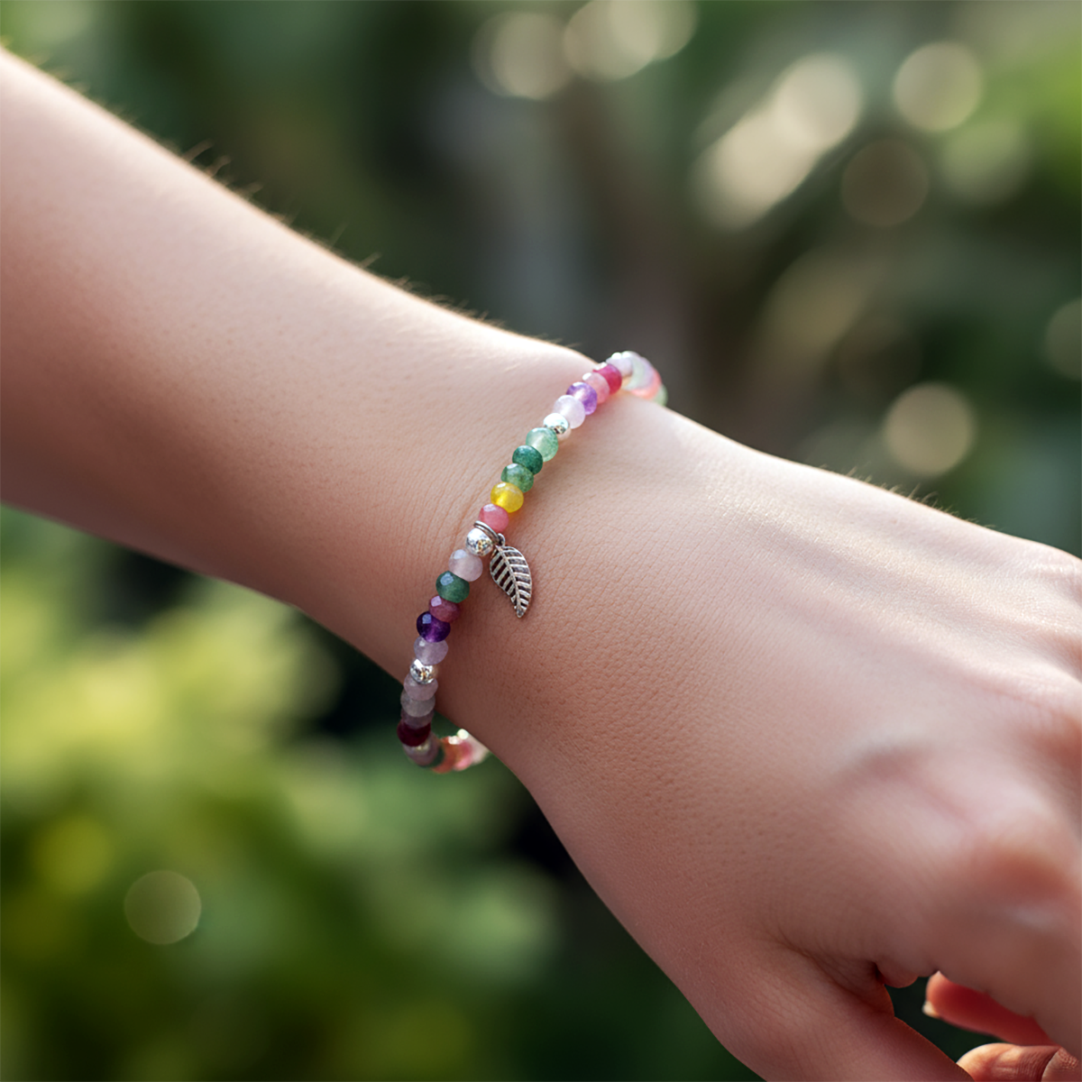 Colorful beaded bracelet on a wrist with a blurred green background
