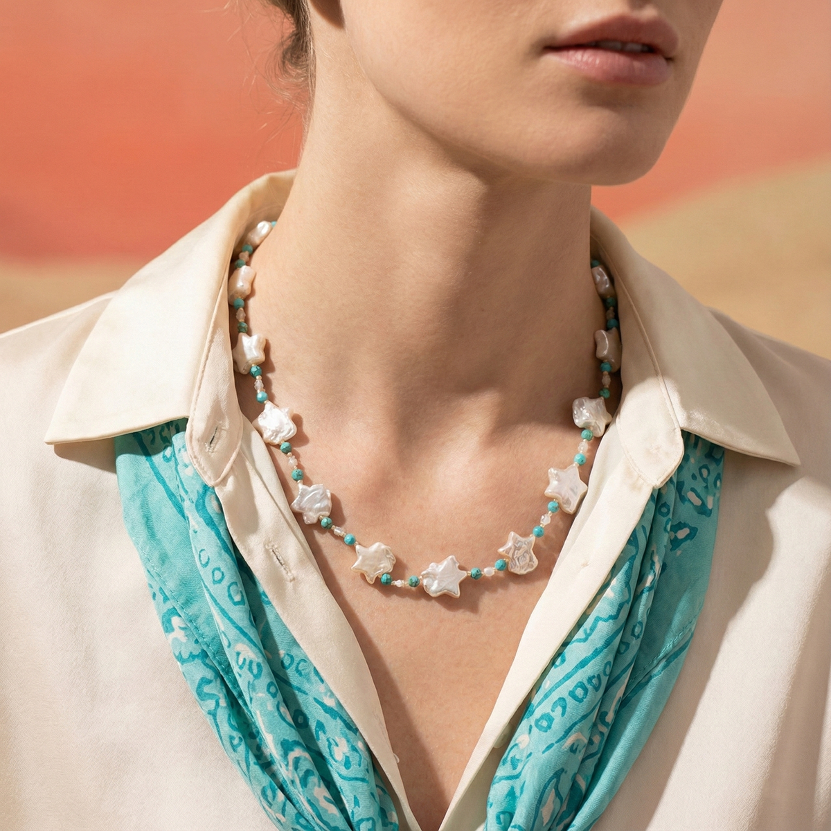 Necklace with star-shaped beads worn by a person against a blurred background