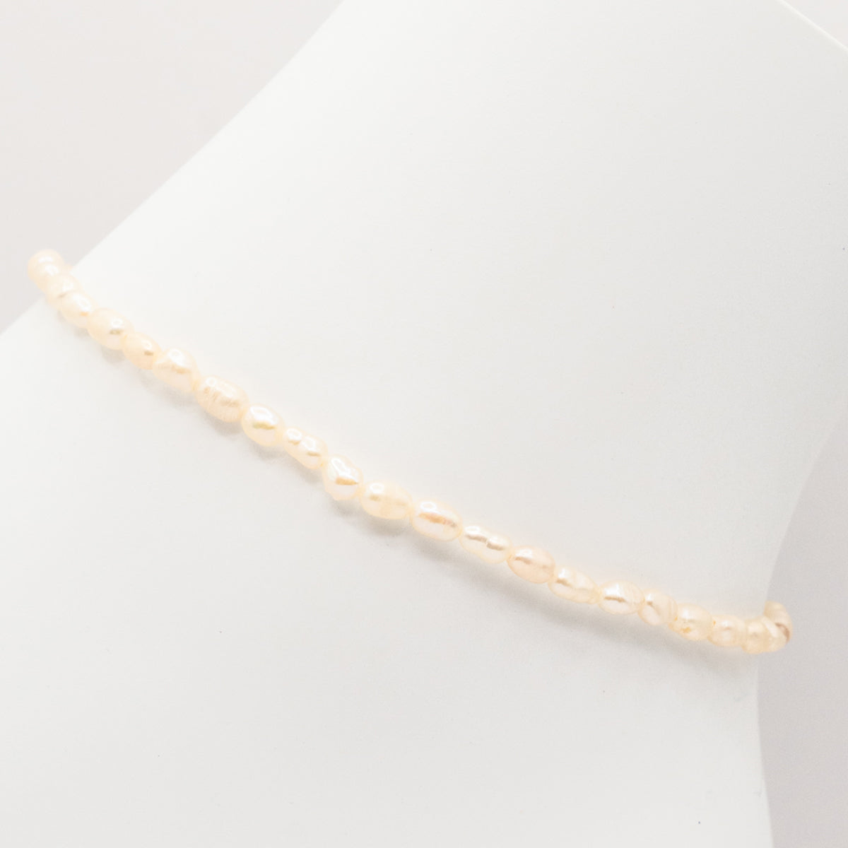 Gold chain necklace on a light gray background