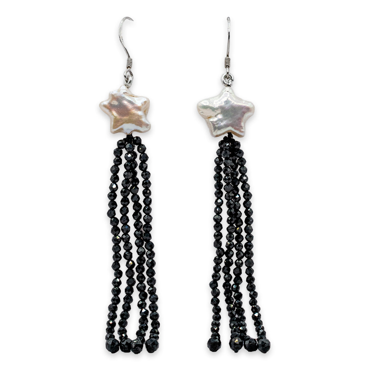 Pair of earrings with star-shaped beads and black tassel on a white background