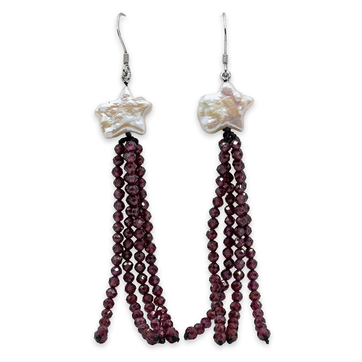 Pair of earrings with star-shaped beads and red beaded tassels on a white background