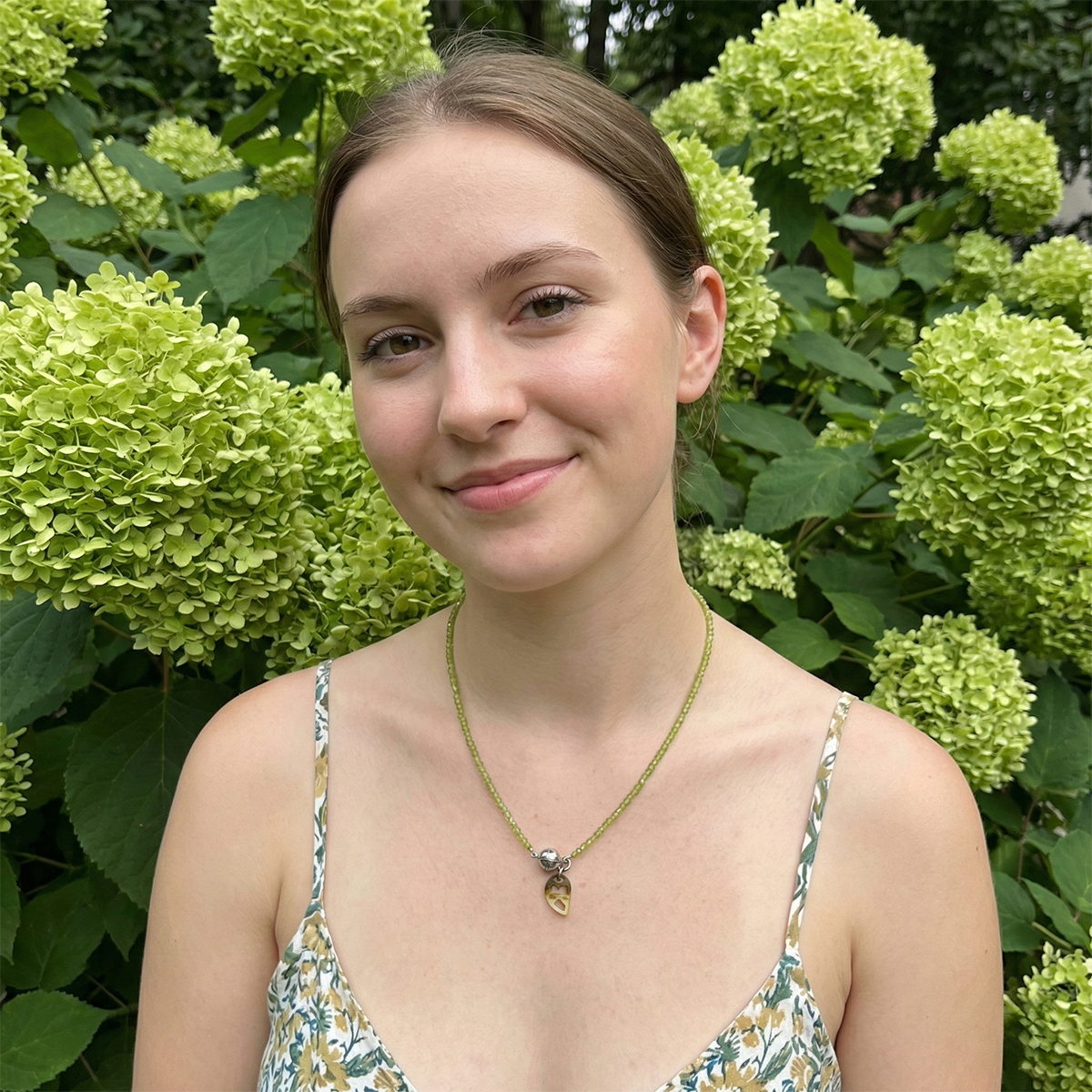 Woman standing in front of green hydrangea flowers