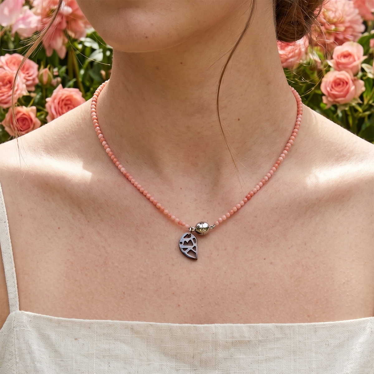 Necklace with a paw print charm worn by a person against a floral background