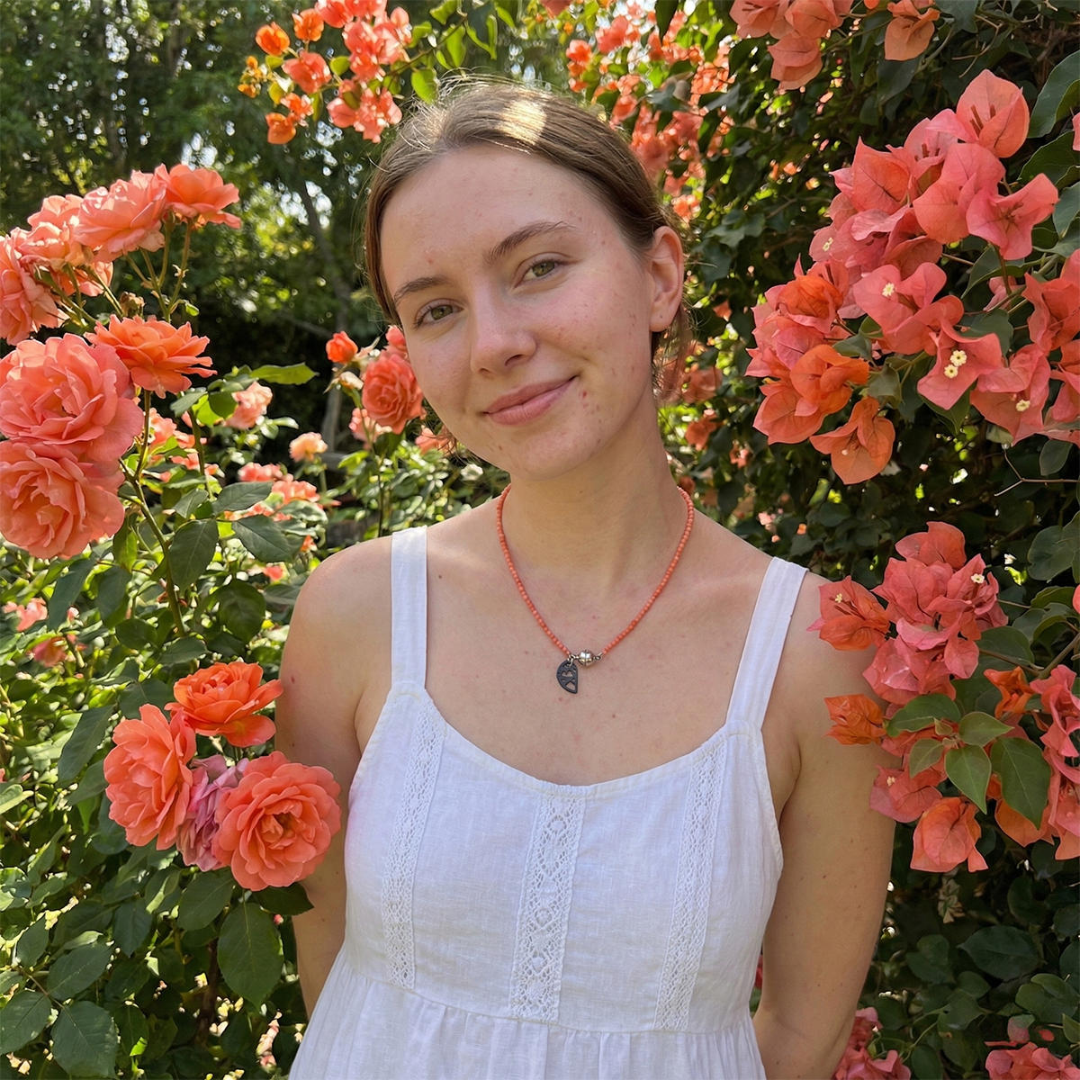 Woman in a white dress standing among pink flowers