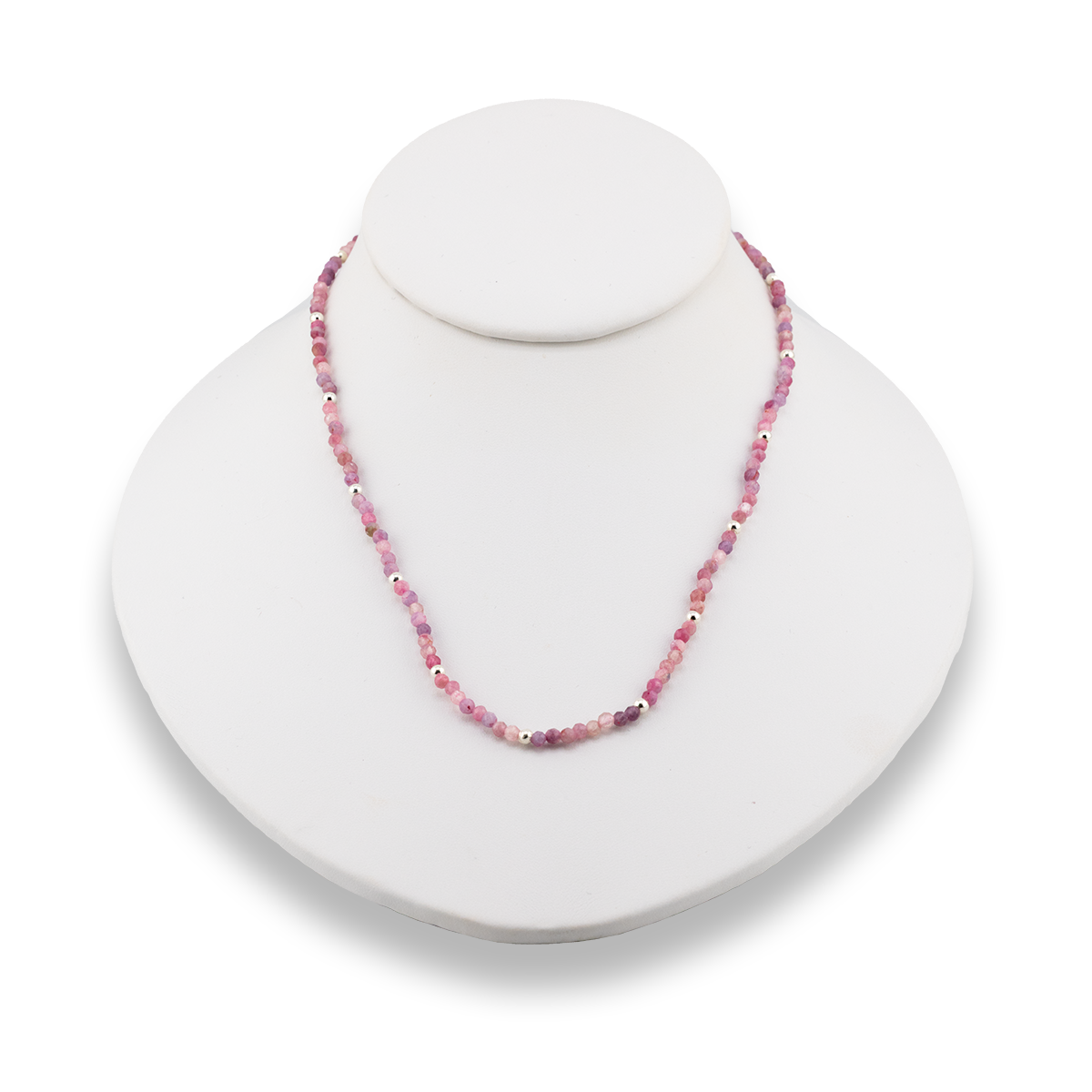 Necklace with pink beads on a white stand against a white background