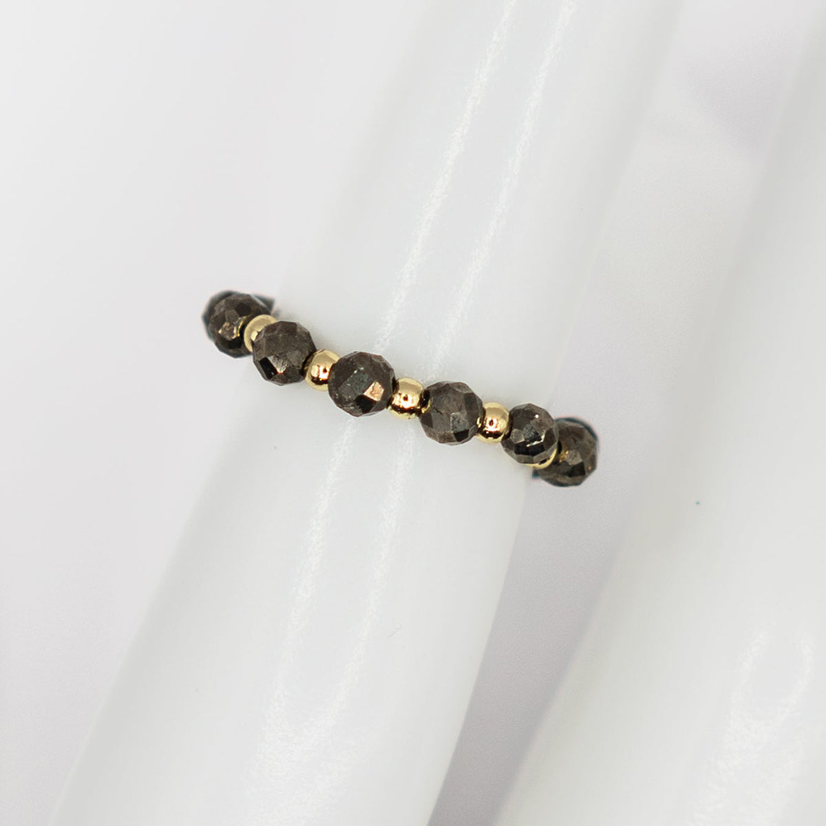 Bracelet with black beads and gold accents on a white background