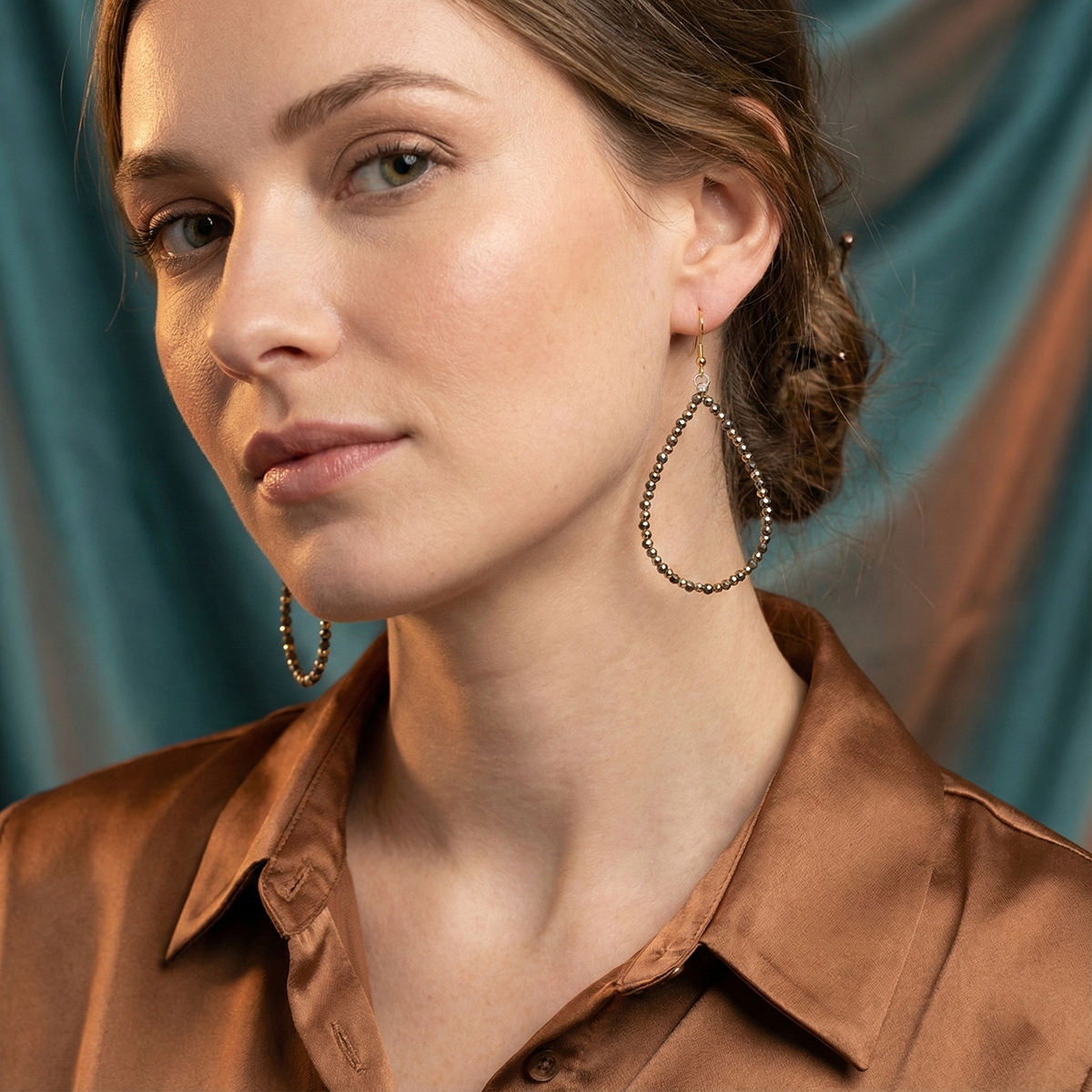 Woman wearing large hoop earrings with a blurred background
