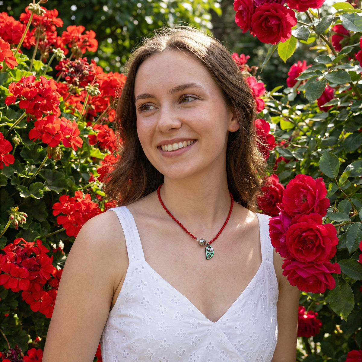 Woman in a white dress standing among red flowers