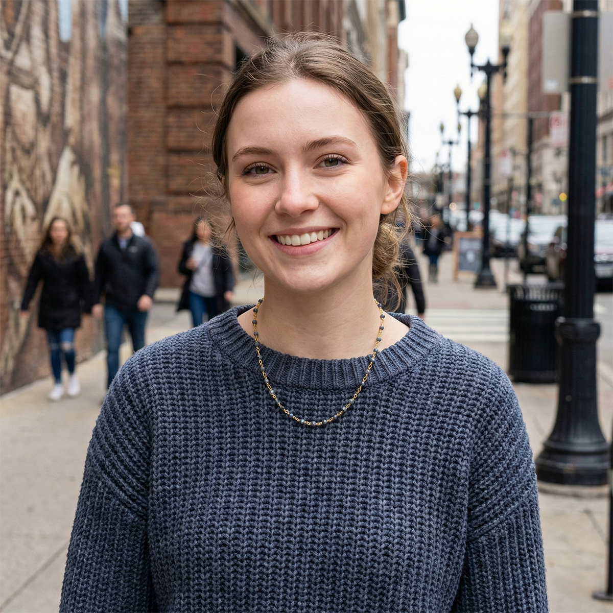 Woman in a blue sweater standing on a city street