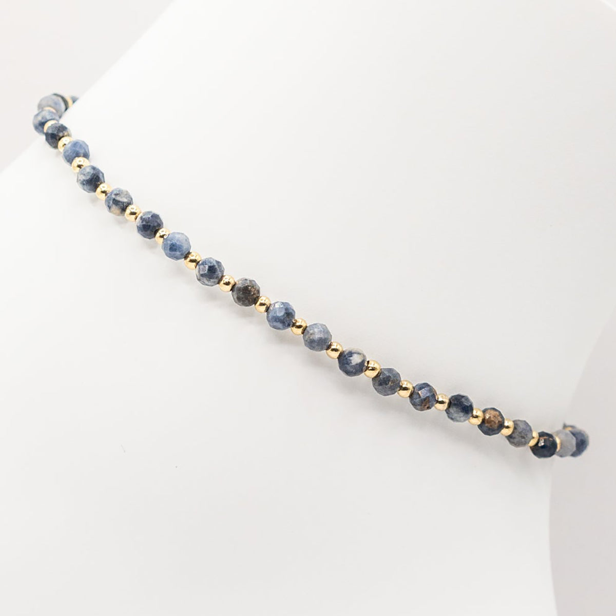 Necklace with blue beads and gold accents on a white background
