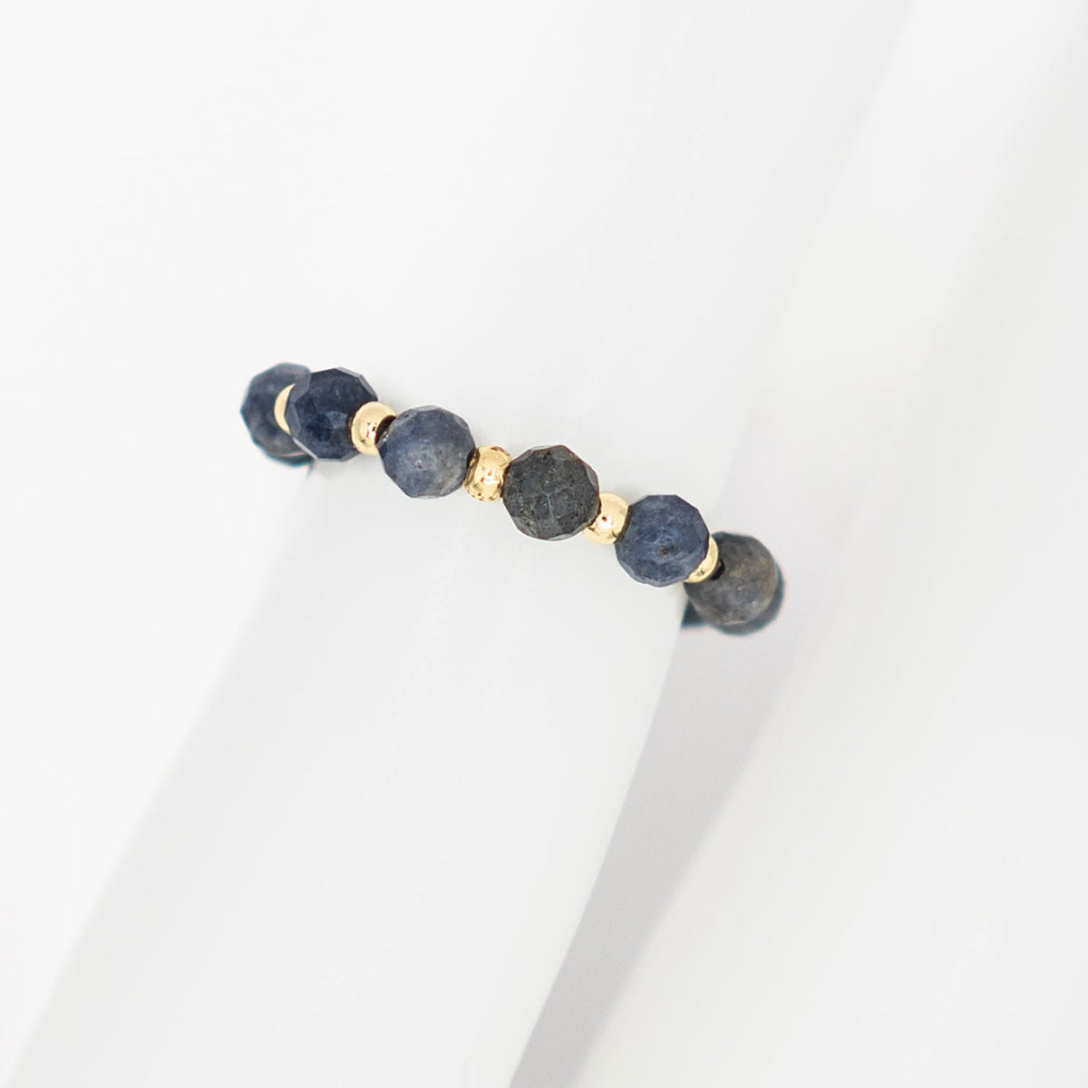 Bracelet with blue beads and gold accents on a white background