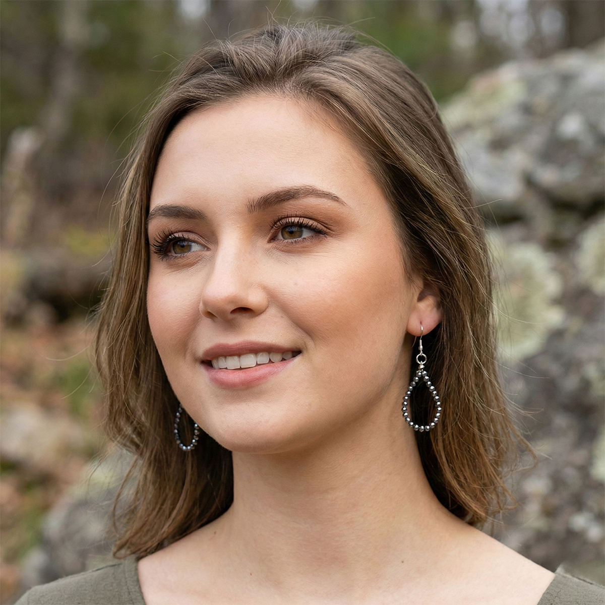 Woman wearing hoop earrings with a natural background