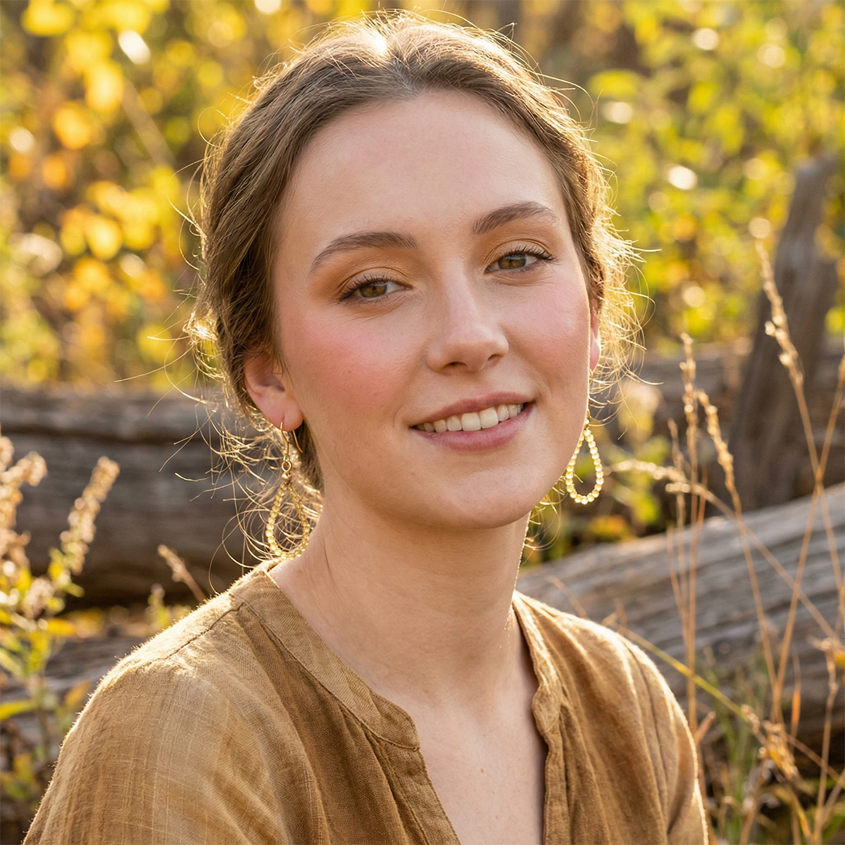 Woman smiling outdoors with blurred natural background