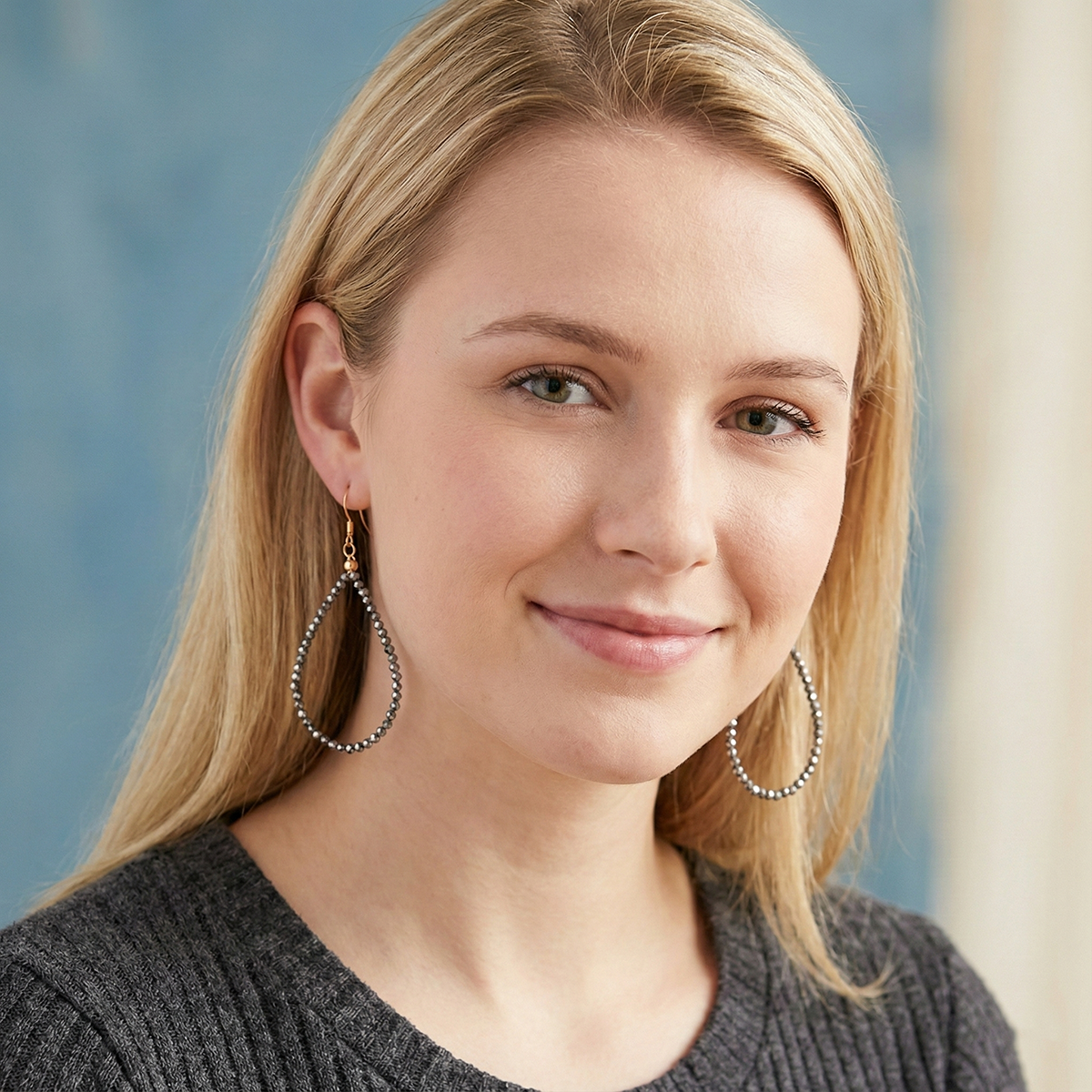 Woman wearing large hoop earrings with a blurred background