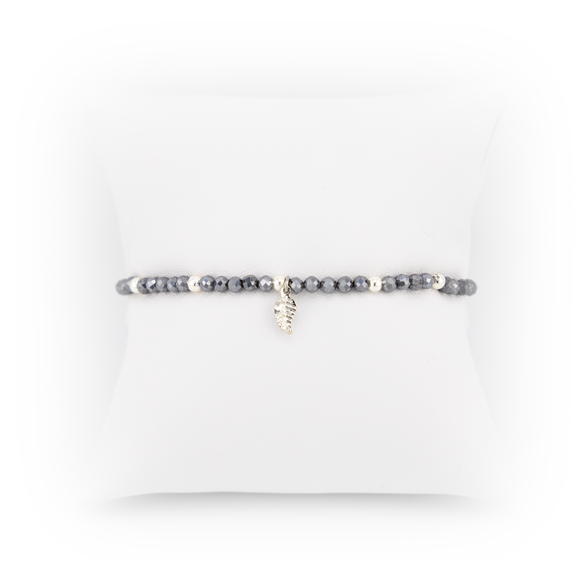 Bracelet with gray beads and a small gold charm on a white background