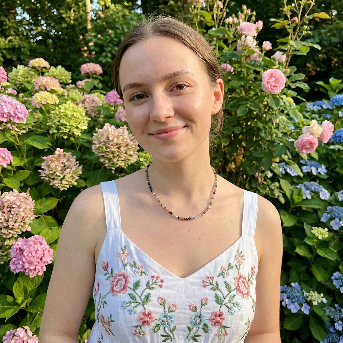 Woman in a floral dress standing in front of colorful flowers