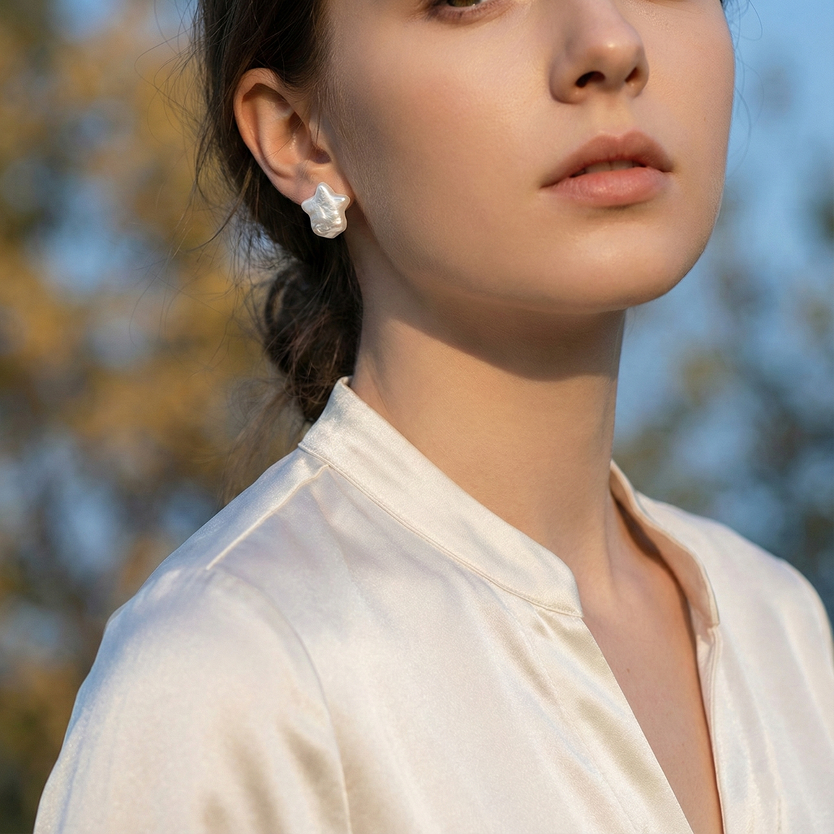 Woman wearing a white blouse with a blurred natural background