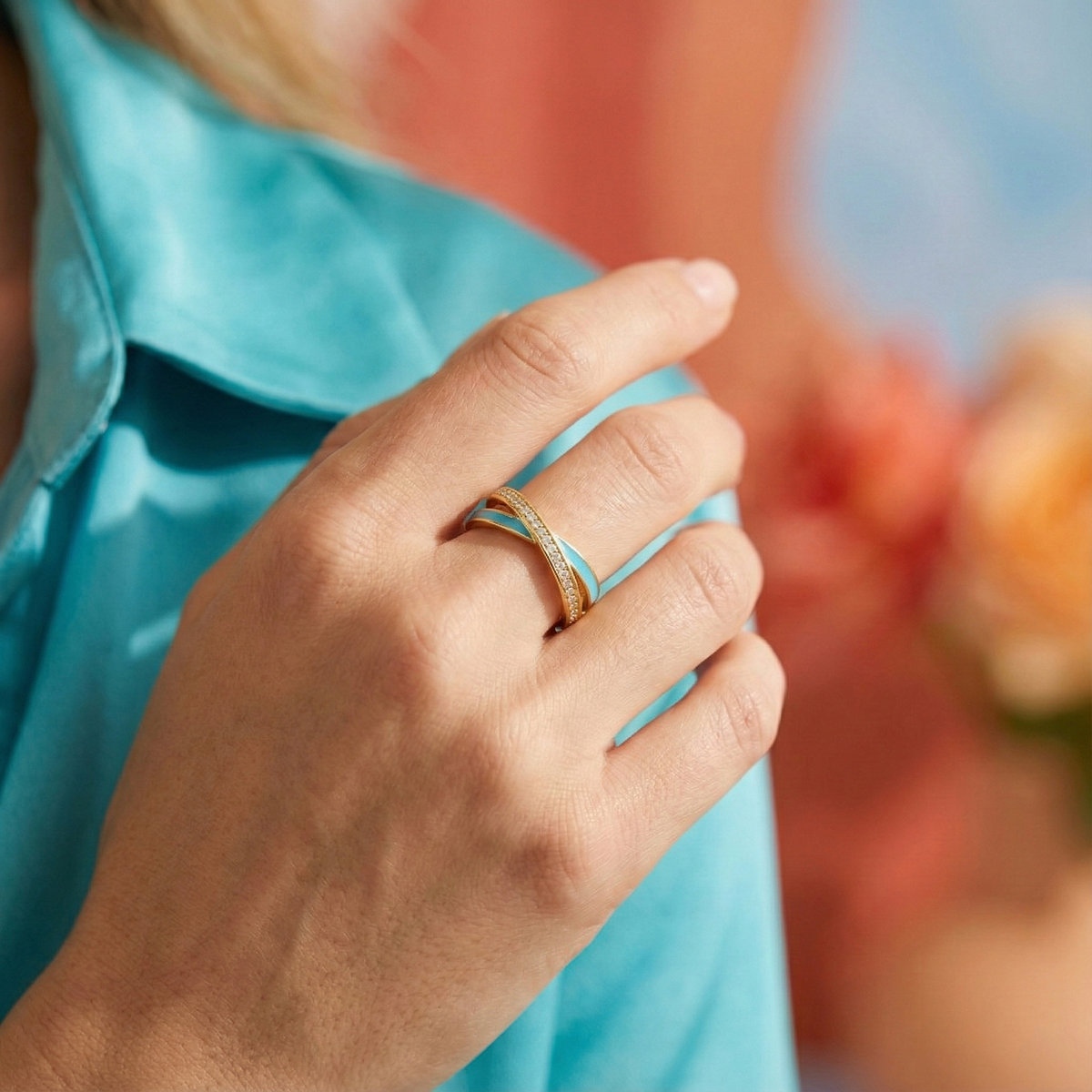Close-up of a hand wearing a gold ring with a blurred background