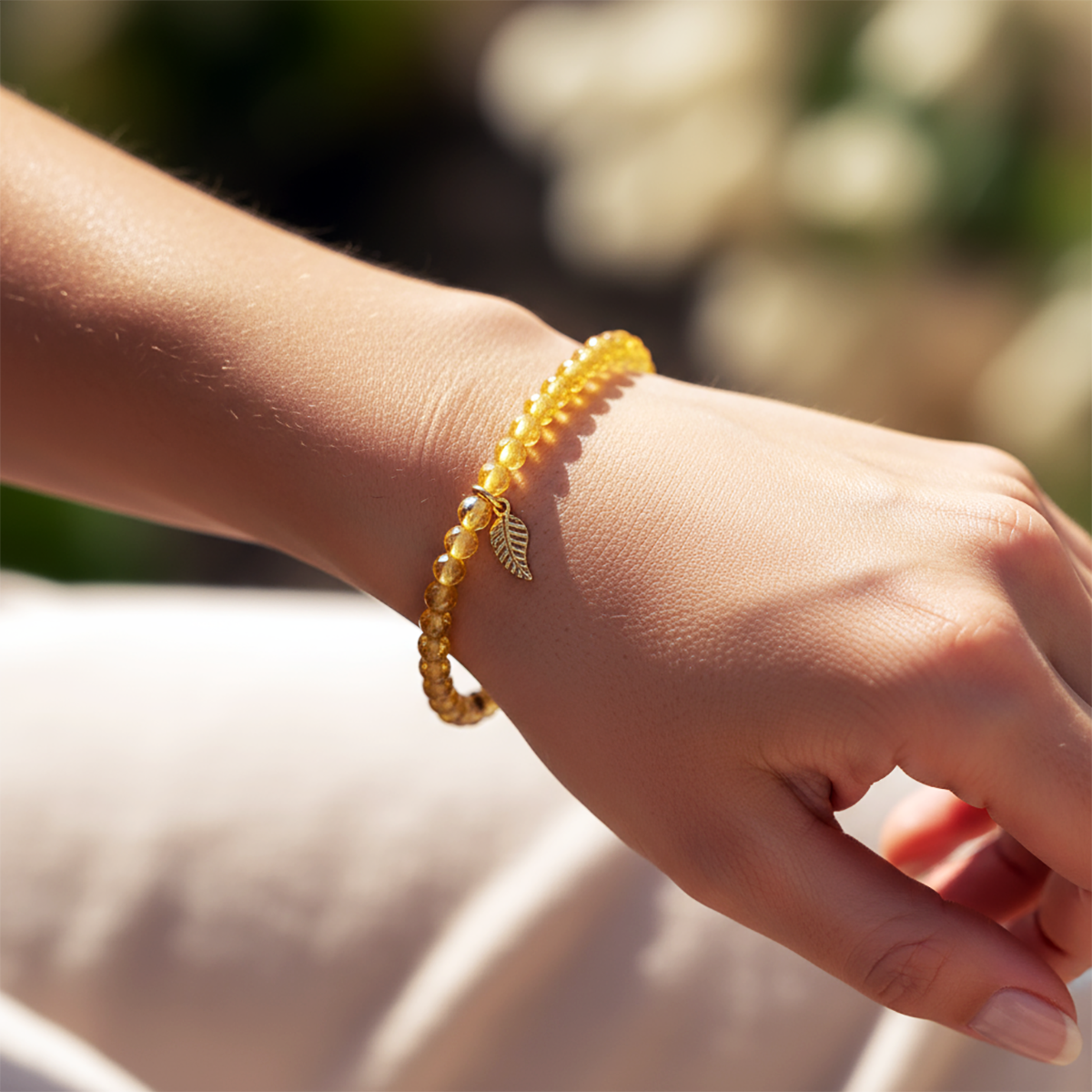 Gold bracelet on a wrist with a blurred natural background