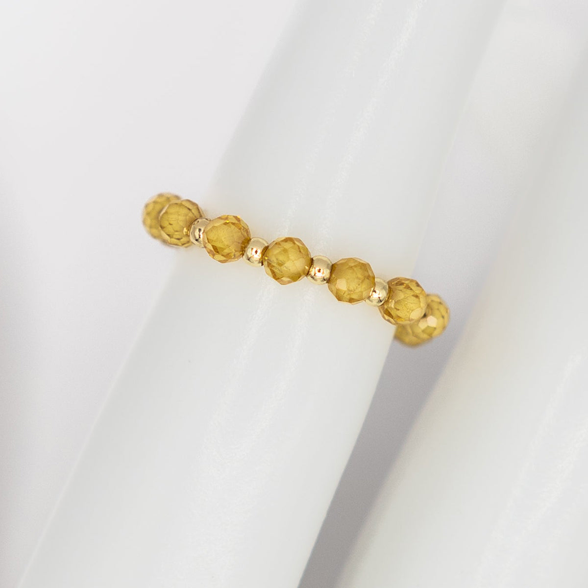 Gold beaded bracelet on a white surface