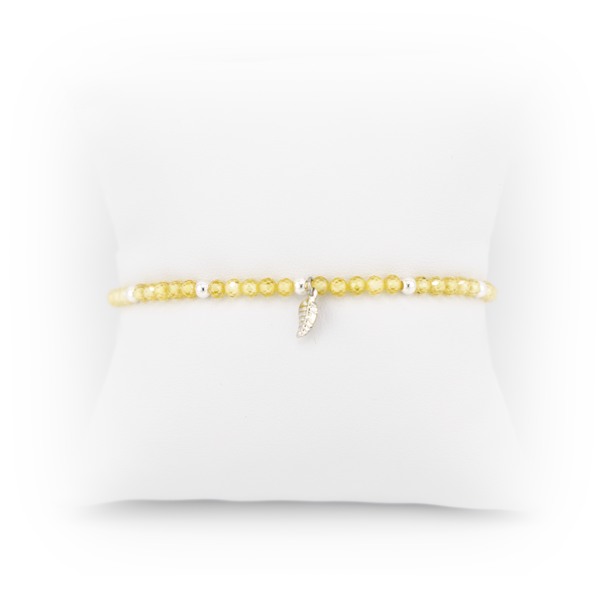 Gold bracelet with a small charm on a white background