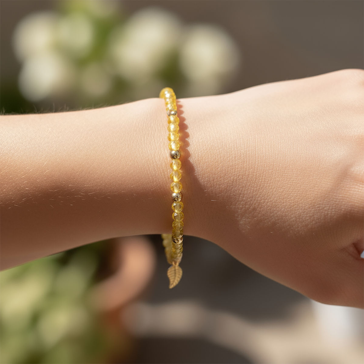 Yellow beaded bracelet on a wrist with a blurred natural background