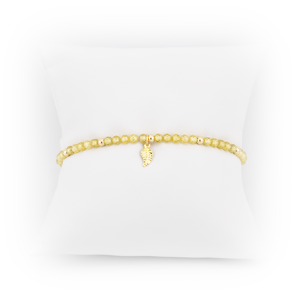 Gold bracelet with a small charm on a white background