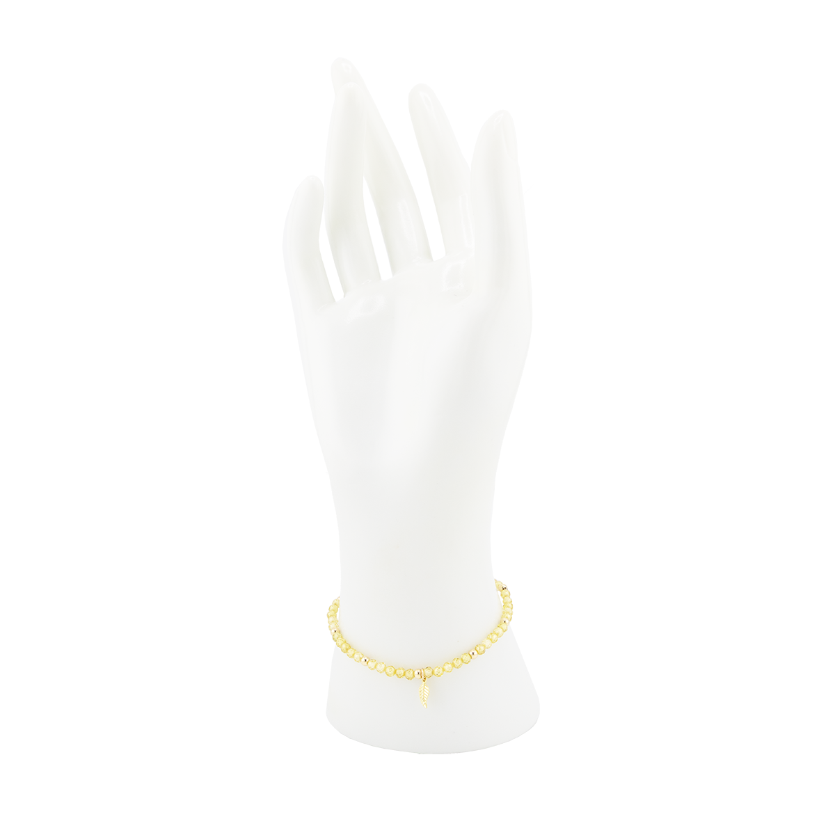 Gold anklet on a white mannequin foot against a white background