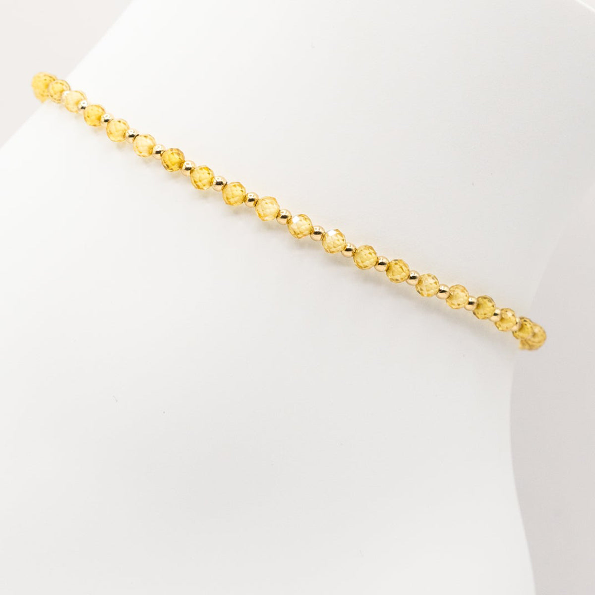 Gold beaded bracelet on a white background