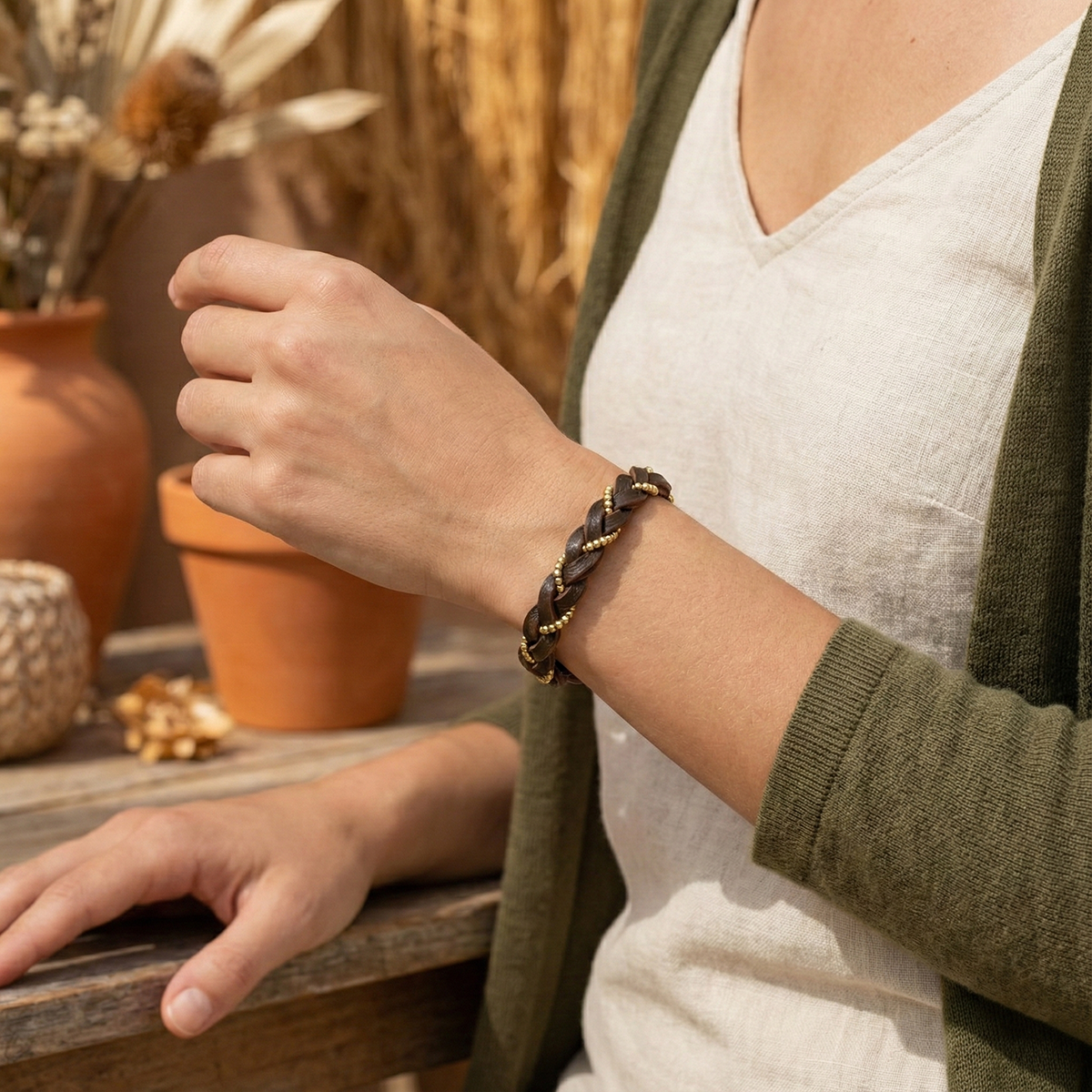 Person wearing a braided bracelet with a neutral background