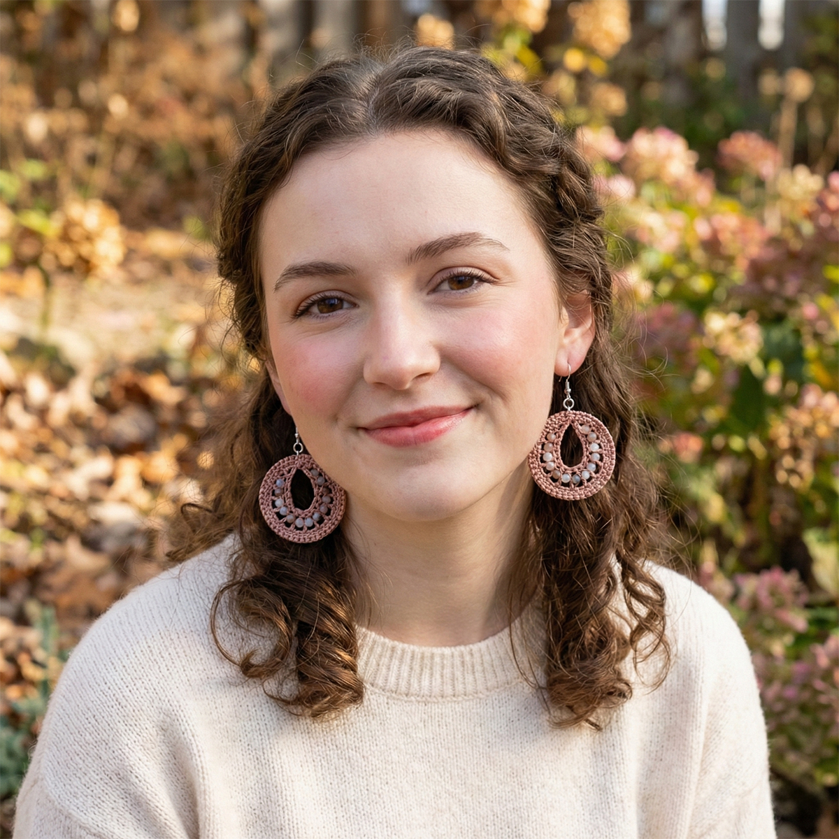 Woman wearing large earrings with a blurred natural background